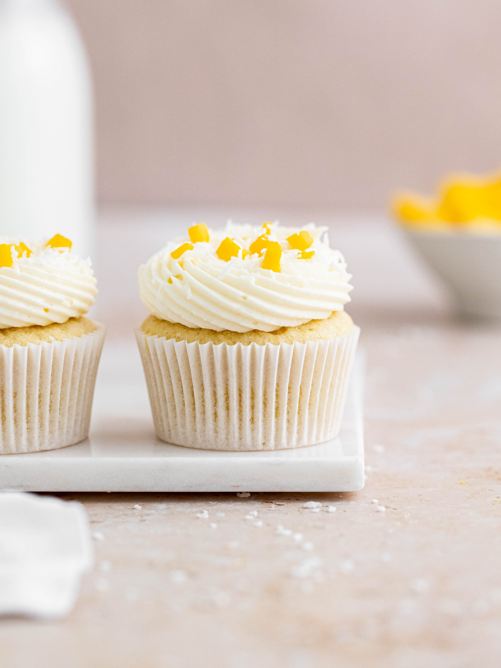 Coconut cupcake, filled with a mango curd and topped with a coconut buttercream