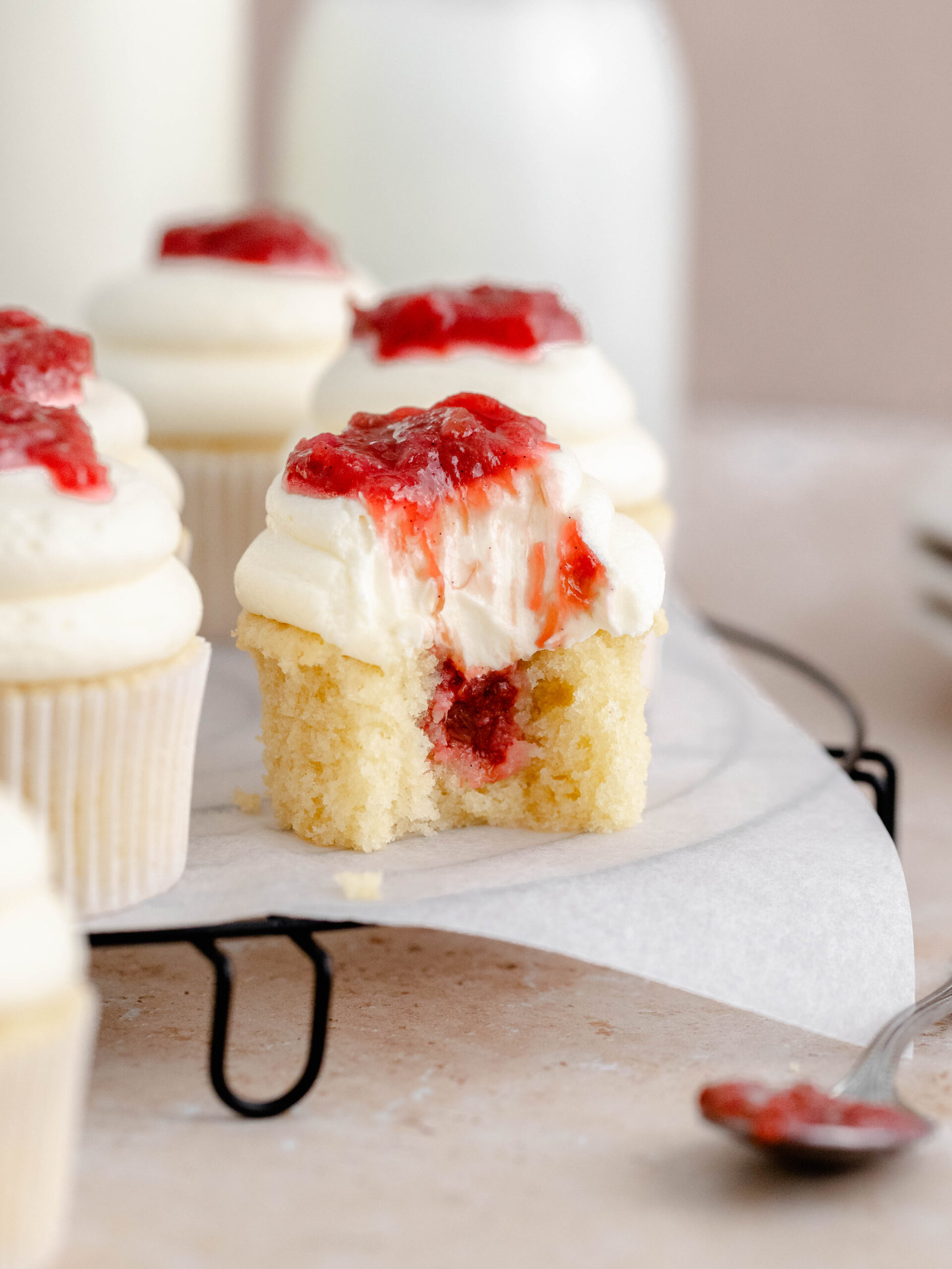 A bite taken off a rhubarb and almond cupcake.