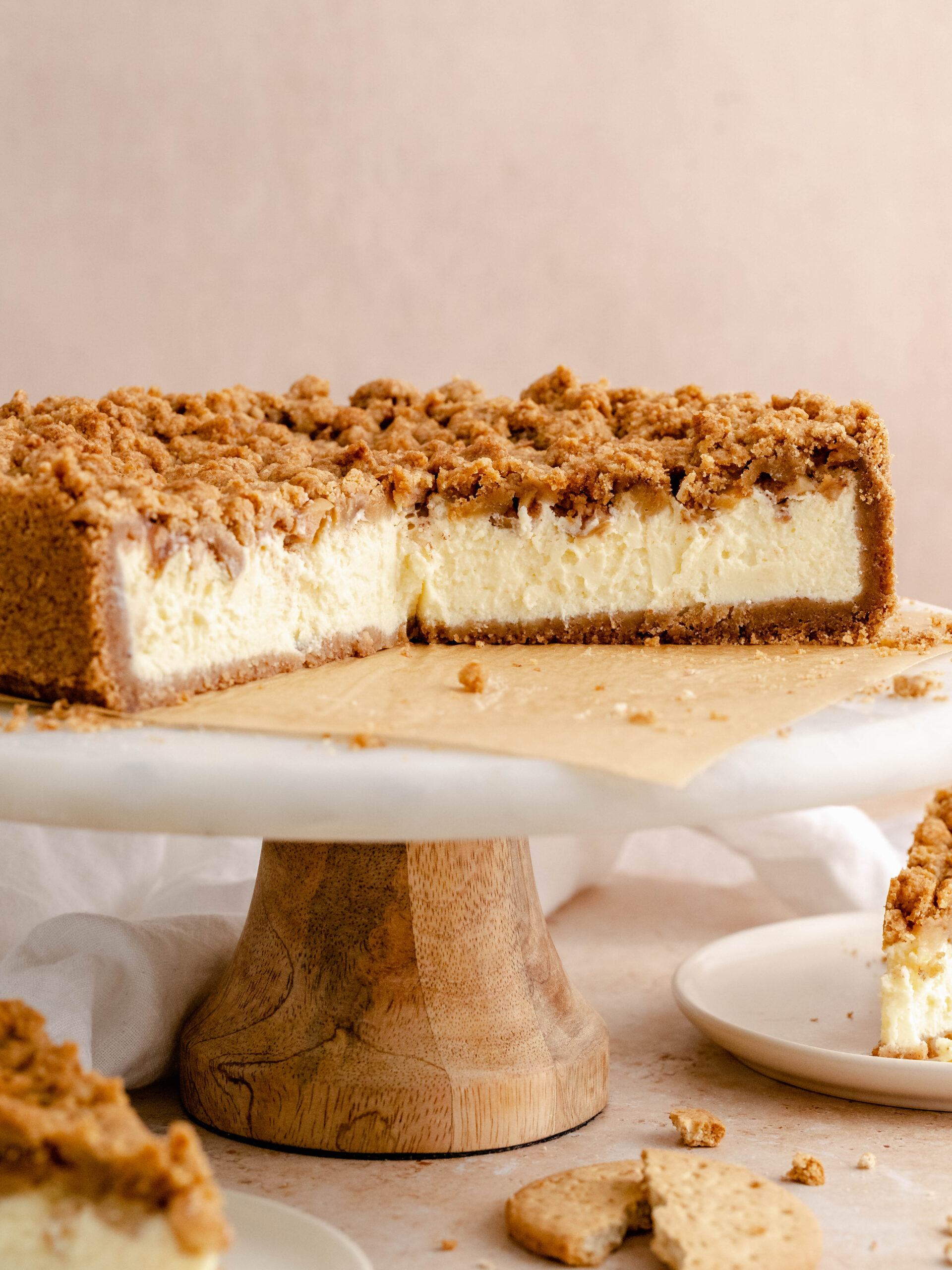 Apple crumble cheesecake on a cake stand.
