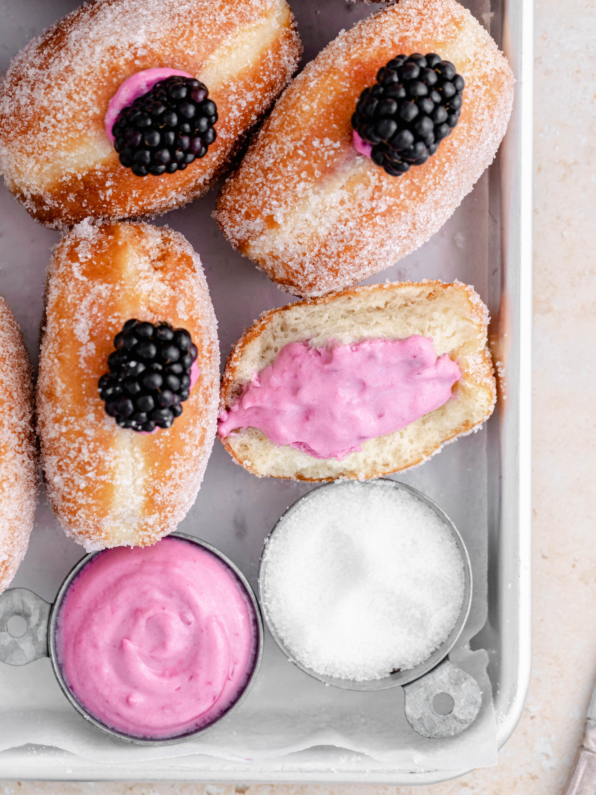 Delicious filled blackberry cheesecake donuts on a tray.