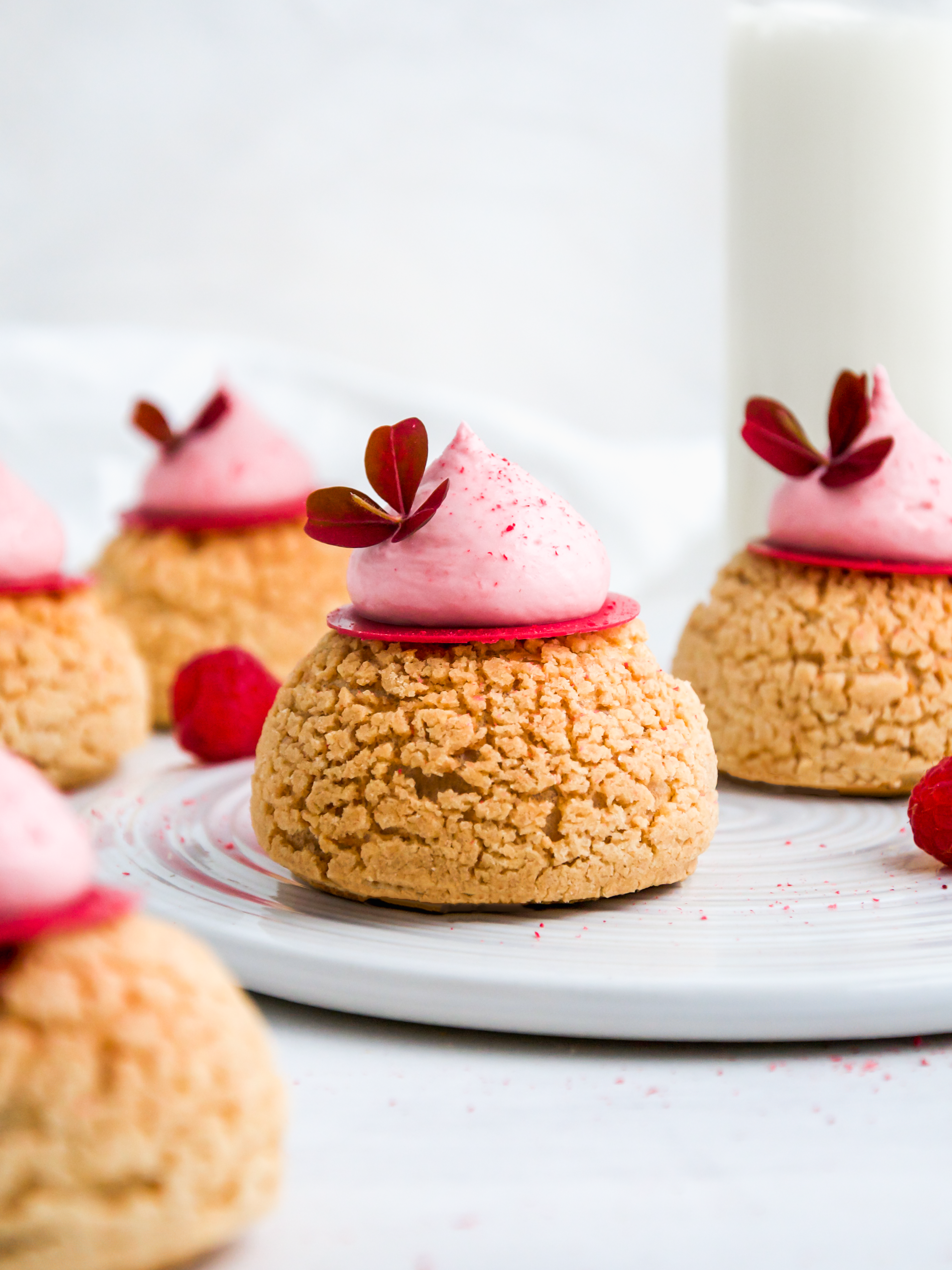 Raspberry Choux au Craquelin on a plate.