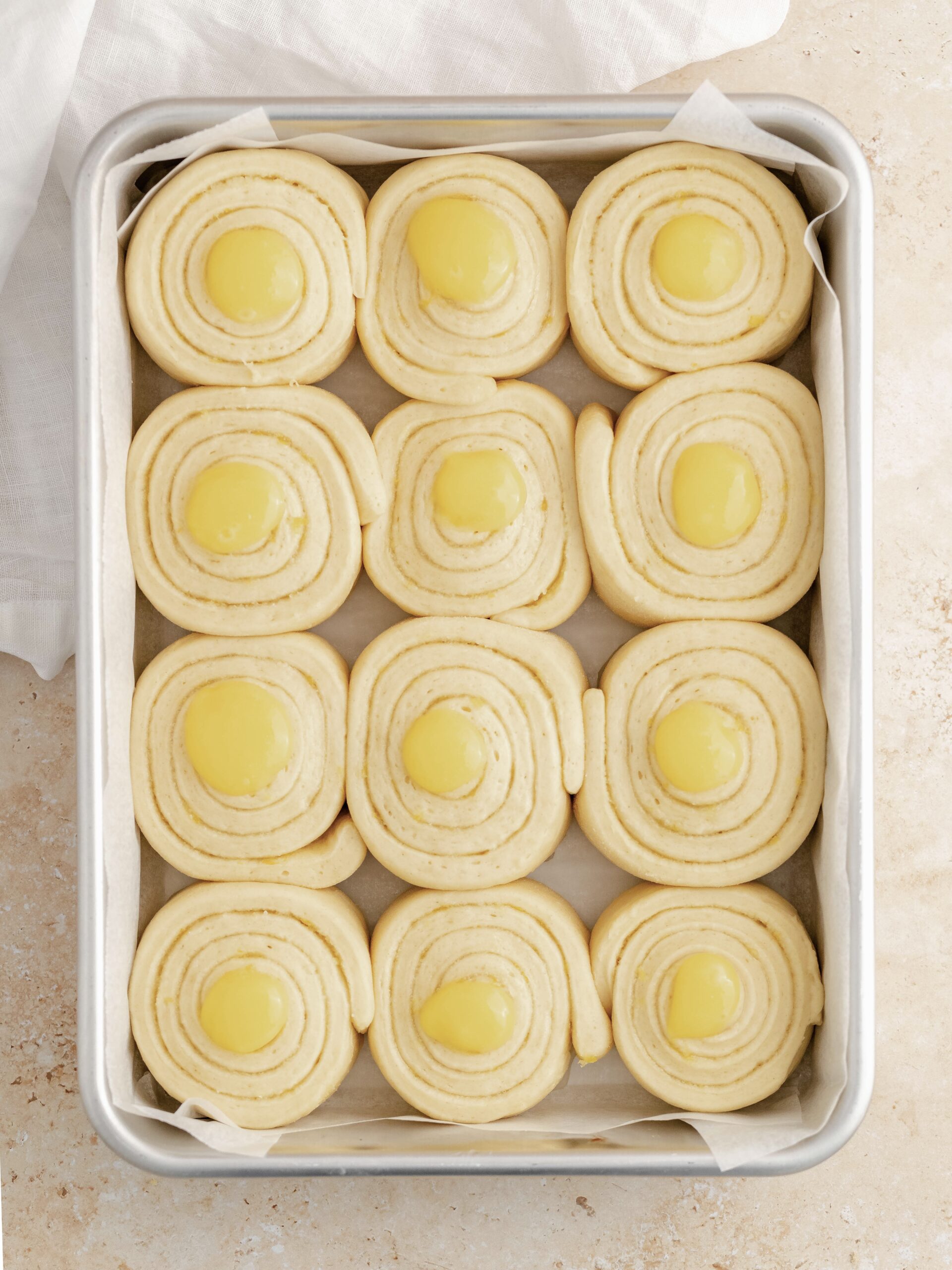 Lemon rolls in the baking tray filled with lemon curd.