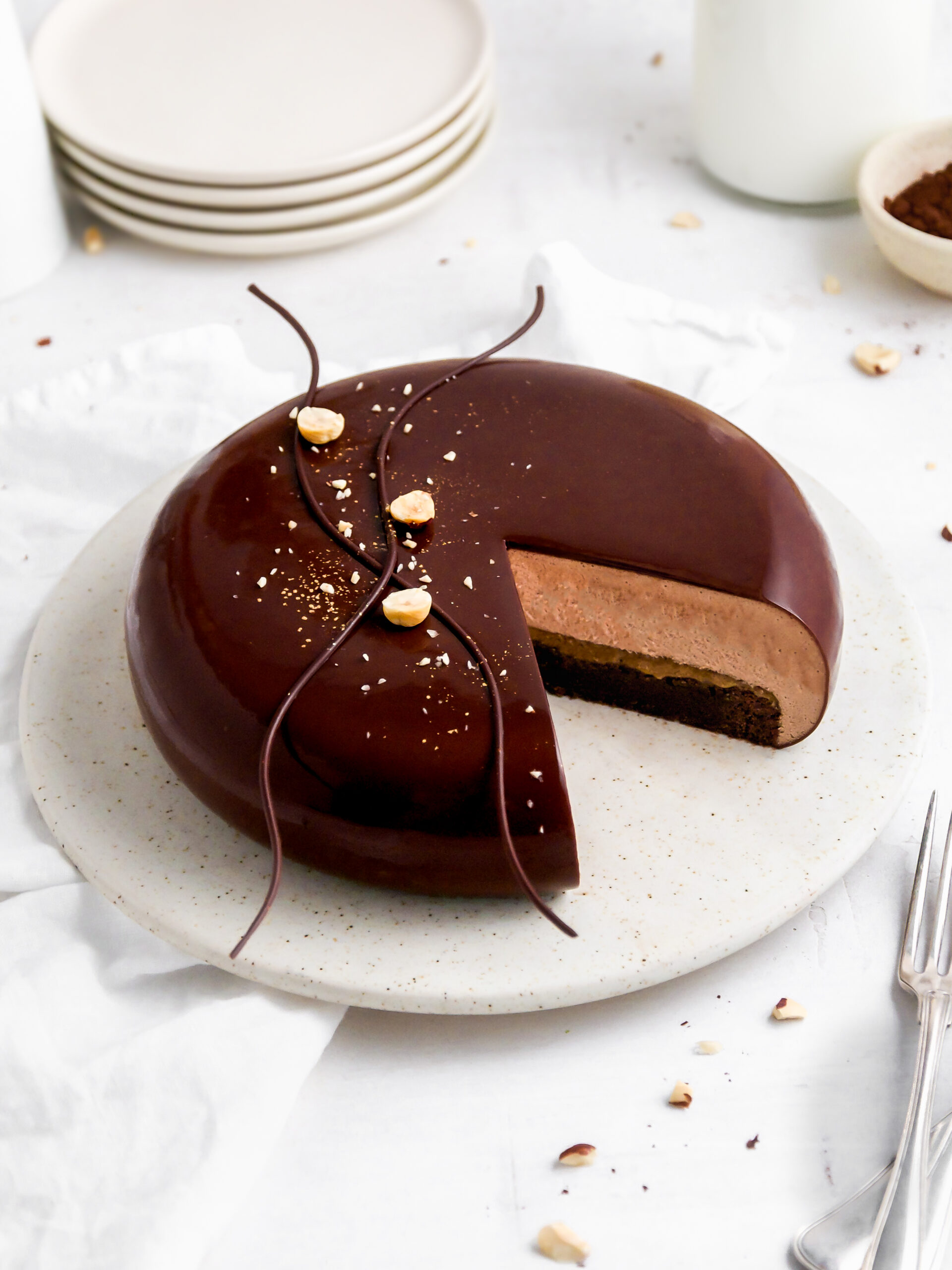 Brownie- og Nutella-moussekage på en kagebakke med en skive skåret i den.