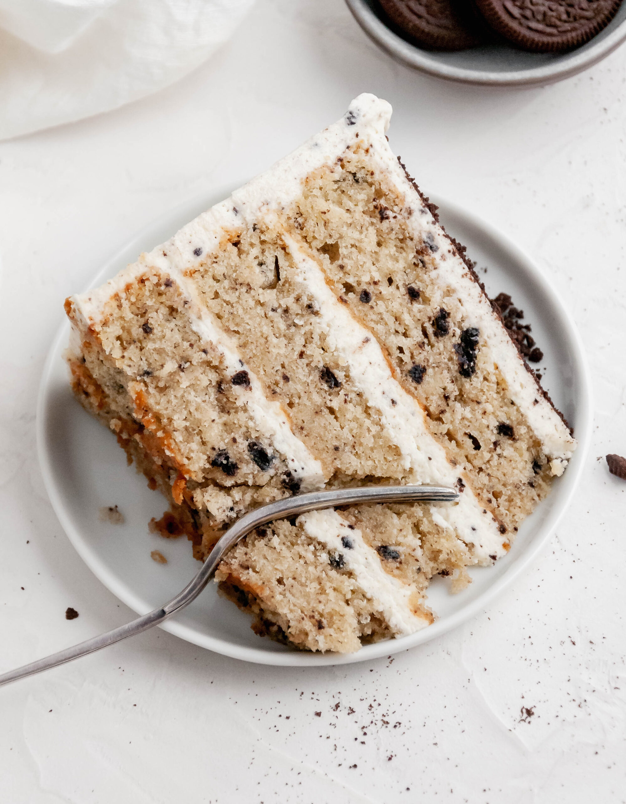 A slice of Oreo layer cake on a plate.