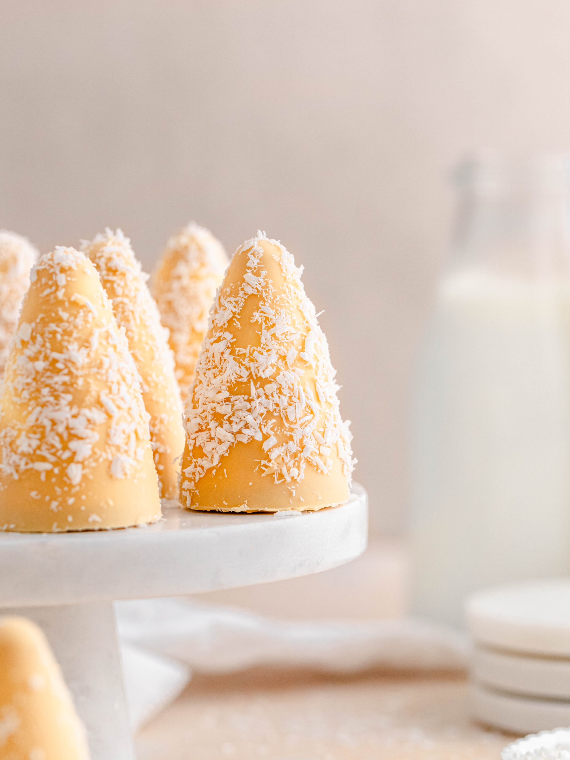 passion fruit and coconut cream puffs  on a cake tray.