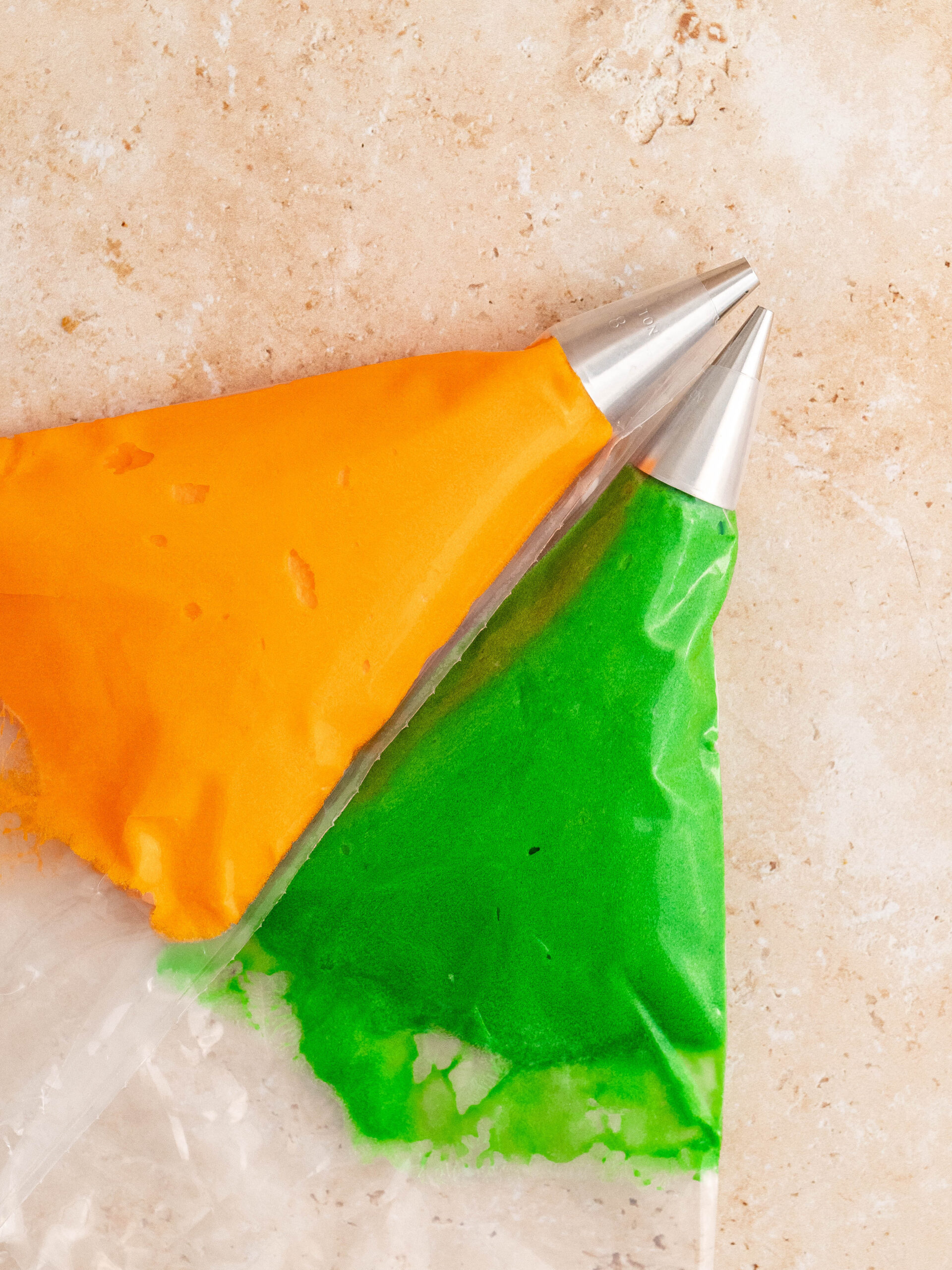 Flødeostglasur farvet orange og grøn, og kom den i en sprøjtepose.