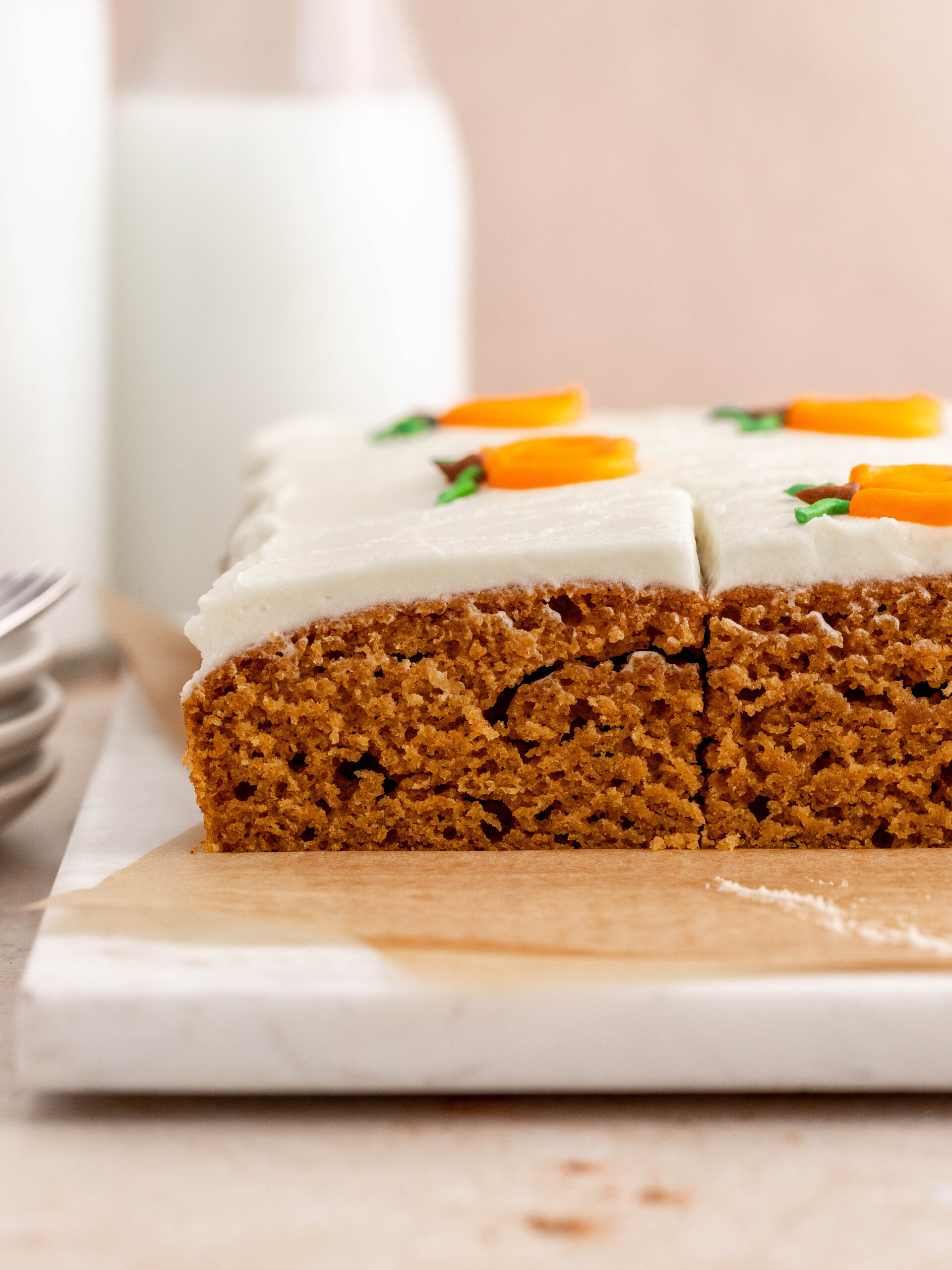 Pumpkin sheet cake cut into slices.