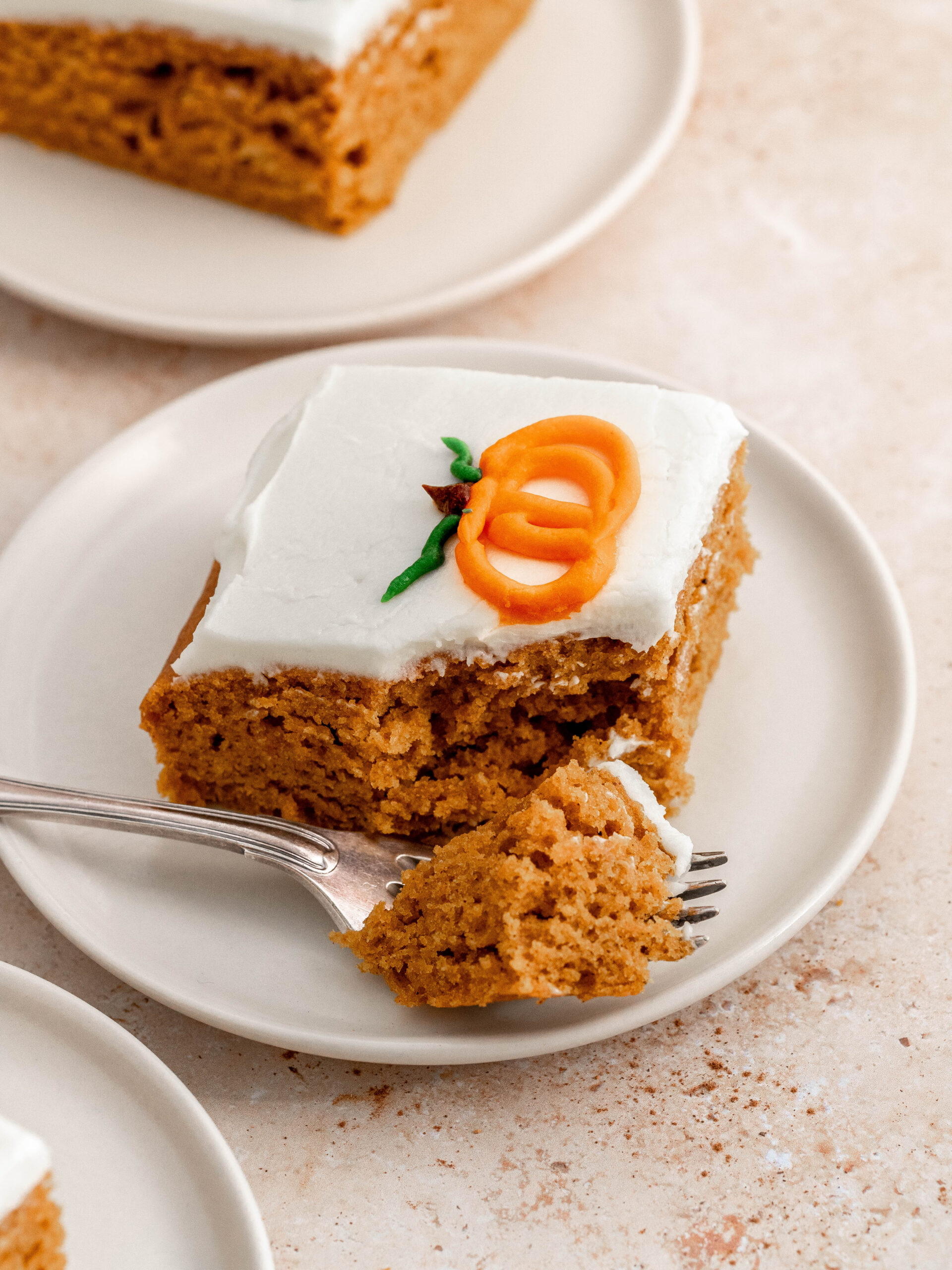 A slice of pumpkin sheet cake on a plate.