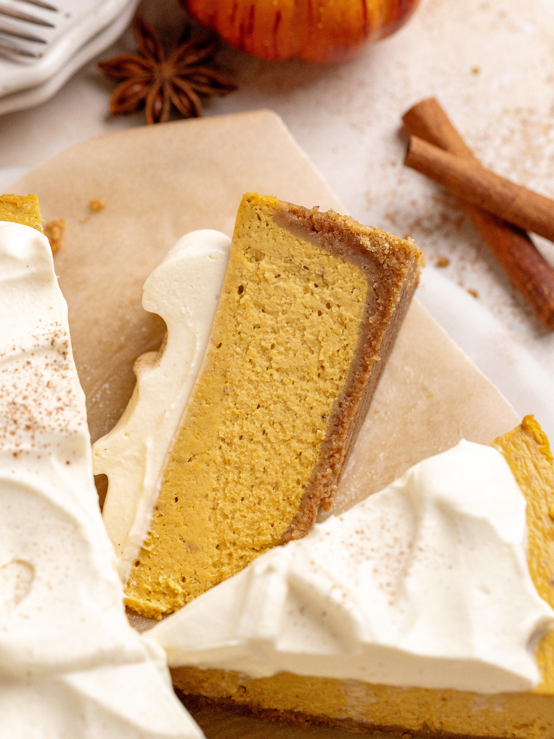 Slice of pumpkin cheesecake laying down