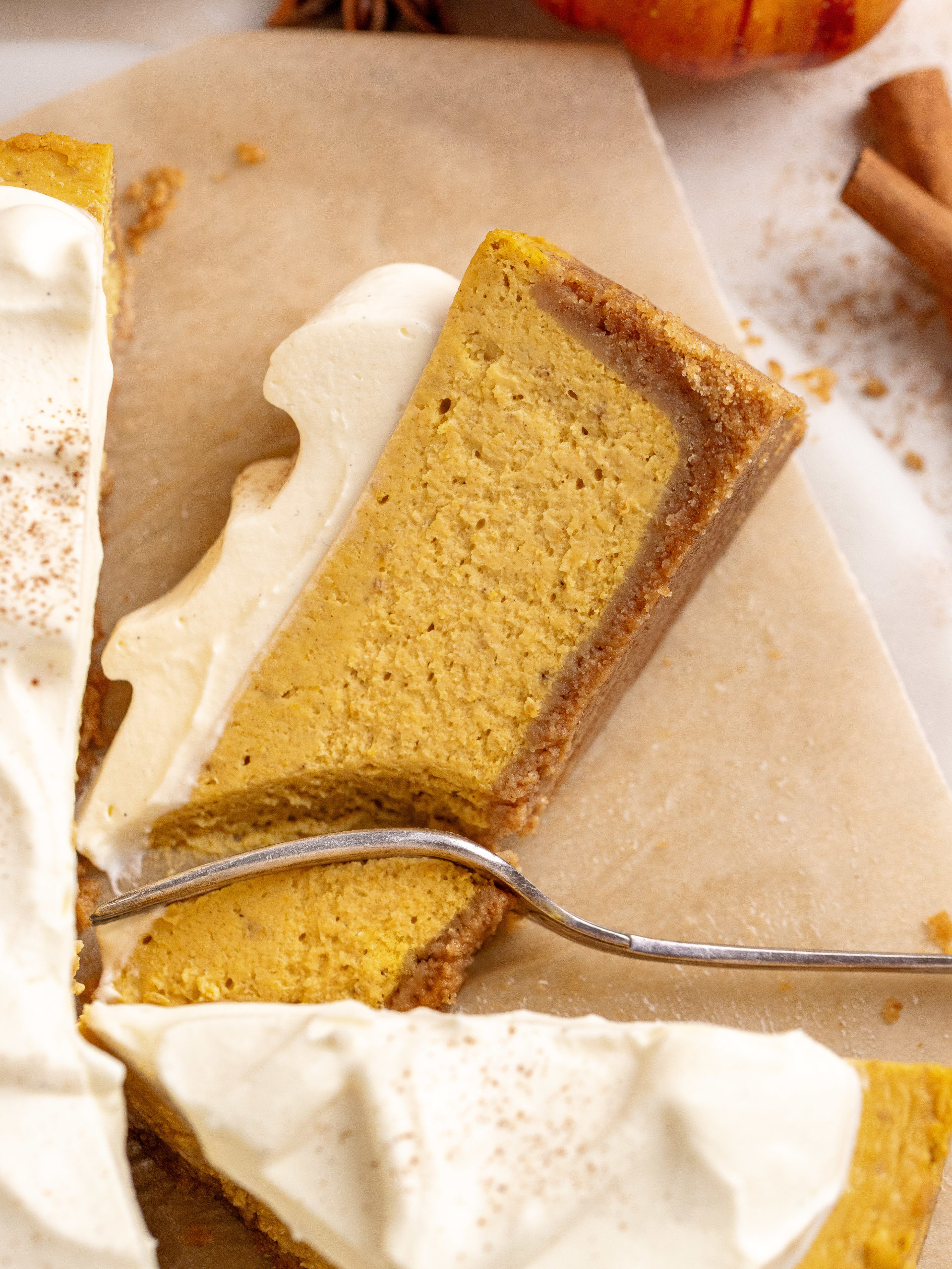 Slice of pumpkin cheesecake laying down