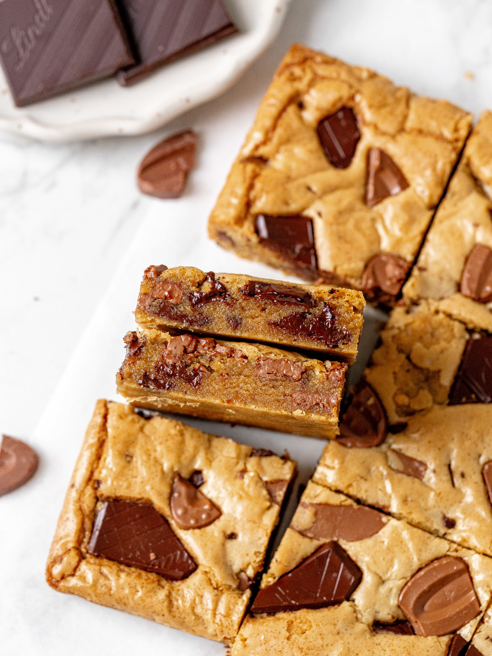 Slices of brown butter blondies with crispy edges and chocolate chunks