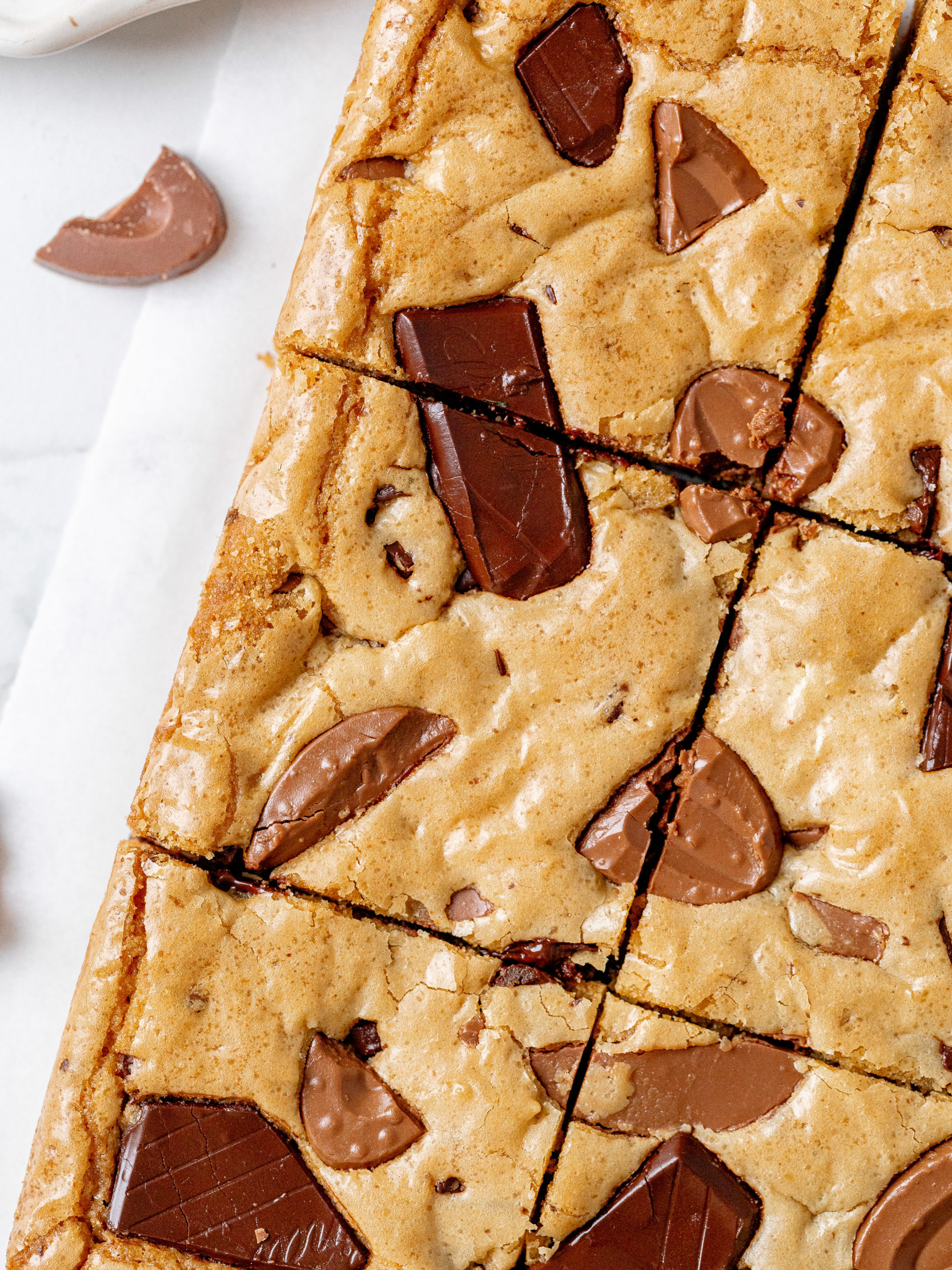 Slices of brown butter blondies with crispy edges and chocolate chunks