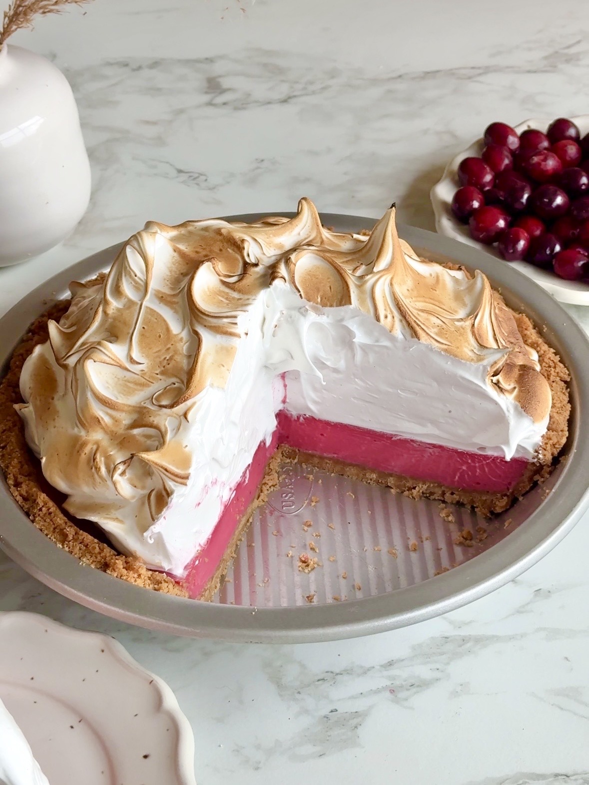 Tærte med tranebær og marengs med en cremet fyldning af tranebærcreme og ristet marengs.